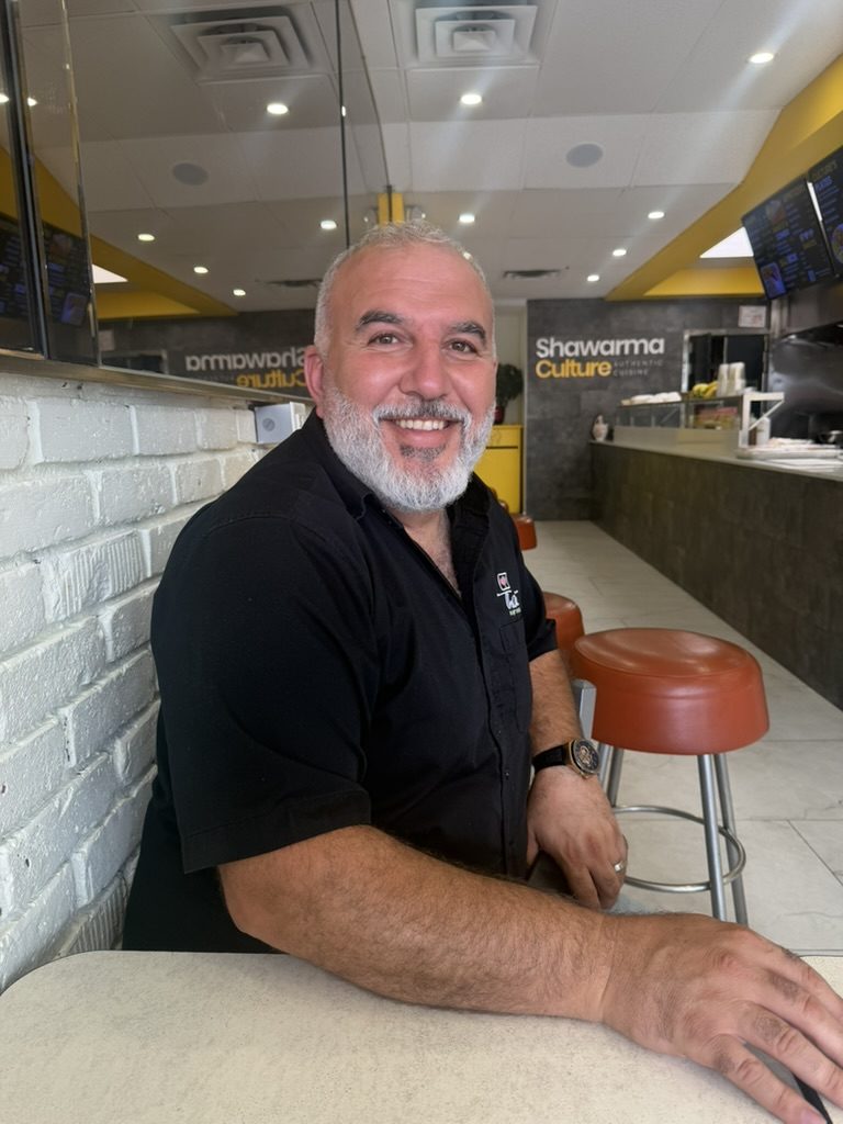 Ahmad, owner of Kebab 44, sitting at the counter of his restaurant